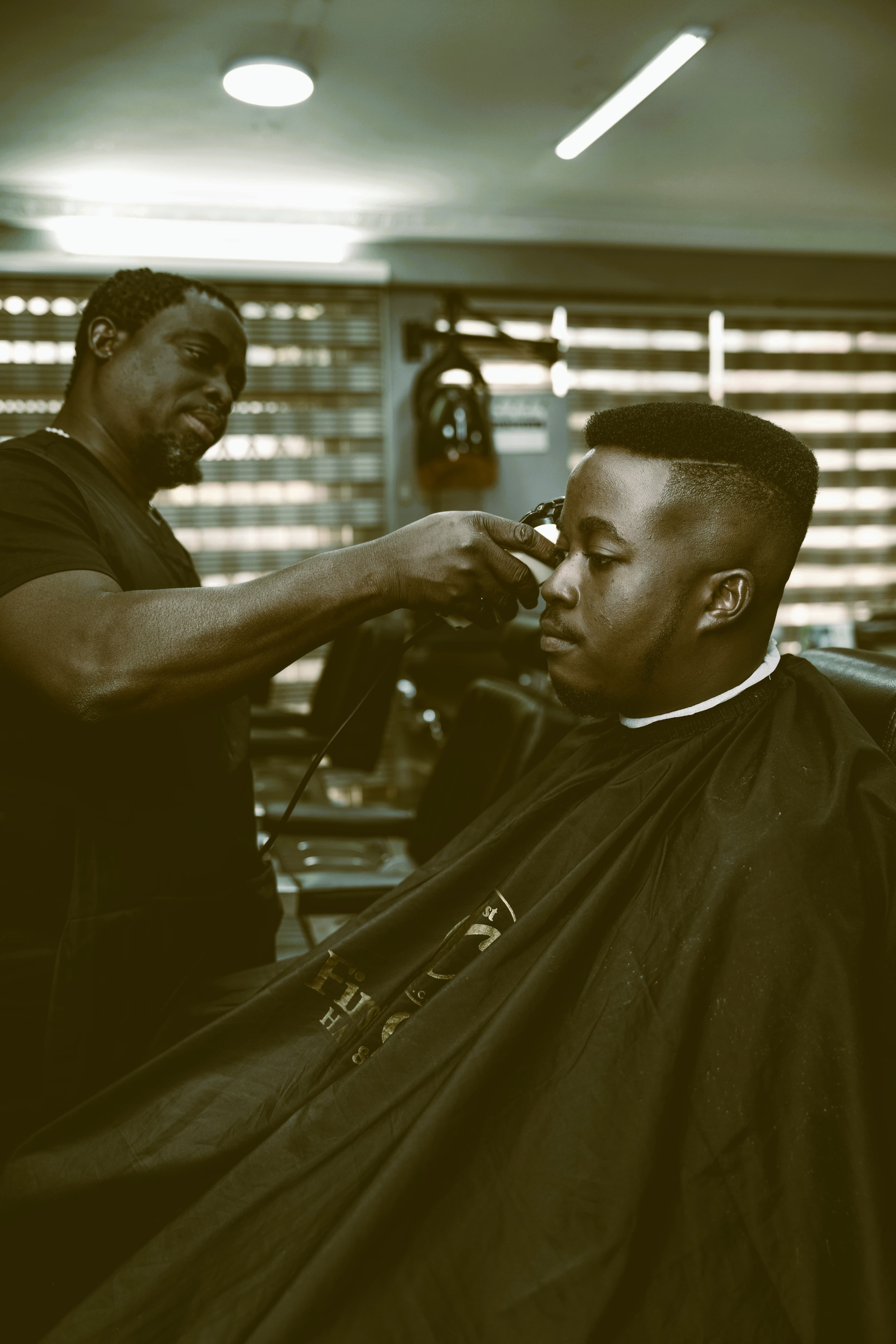 A barber attending to a client in his shop